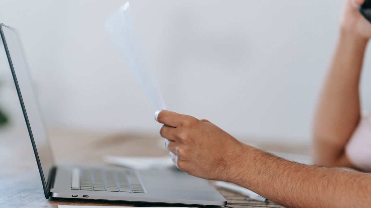 Army soldier reviewing personnel records and promotion data on a laptop