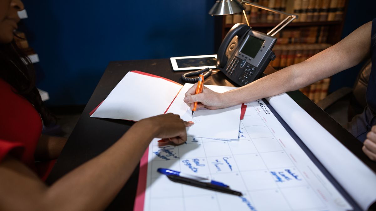 Reserve service member reviewing a work calendar with a civilian supervisor