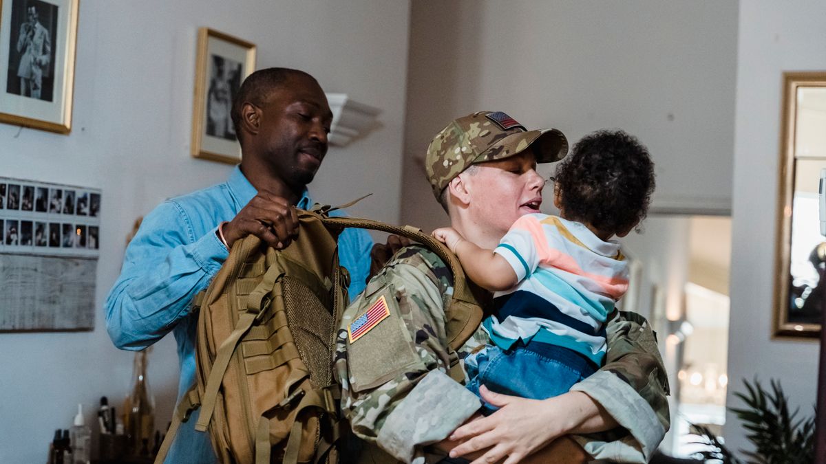 Military family loading travel bags into a car for a PCS trip