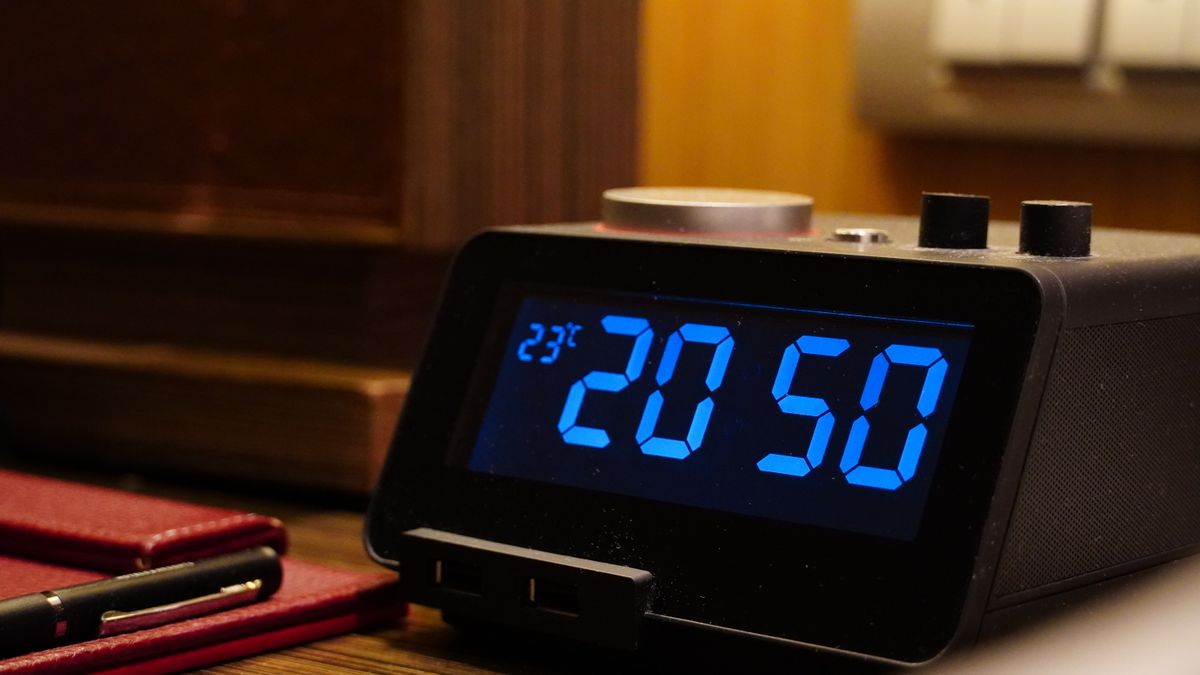 Alarm clock and packed overnight bag in a hotel room before MEPS