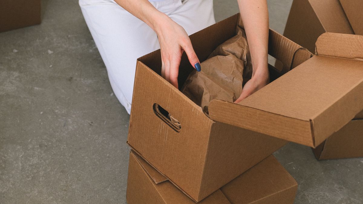 Transitioning service member packing labeled moving boxes in a home