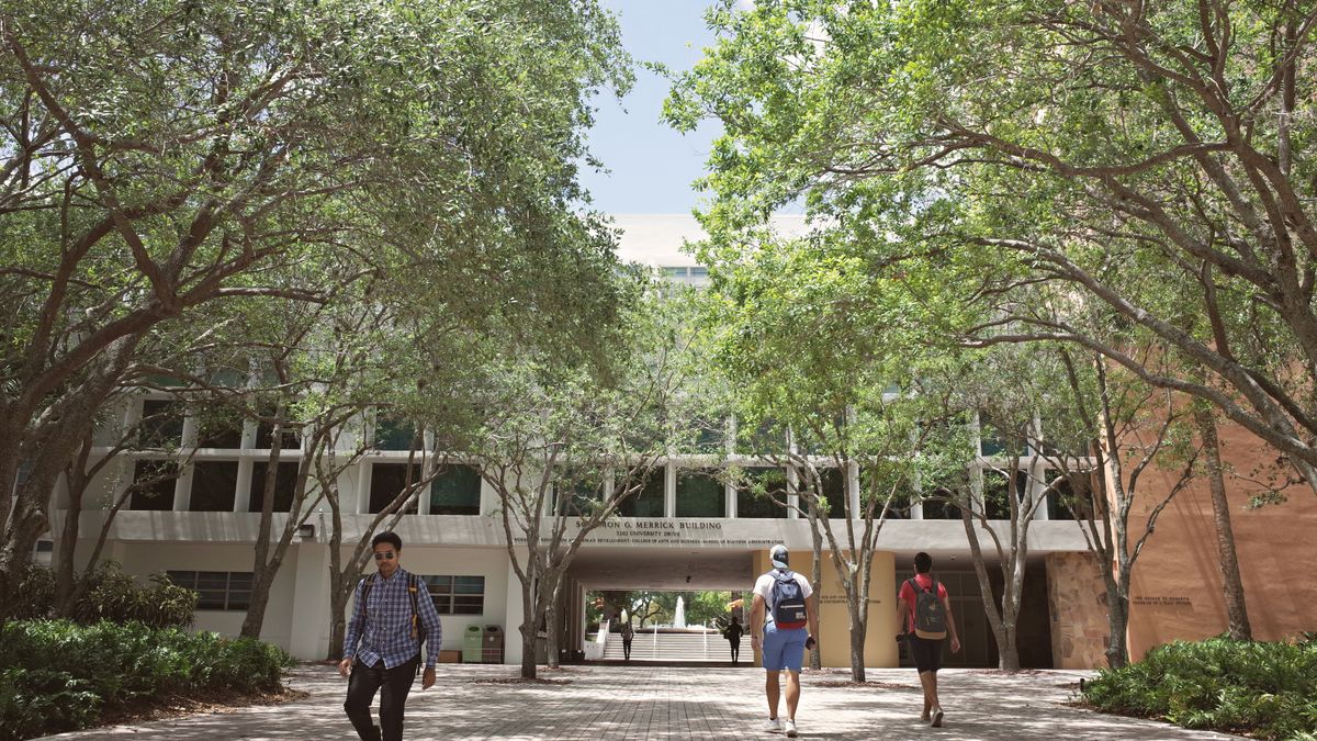 College student walking across campus with a backpack