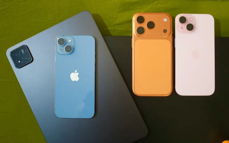Several smartphones and a tablet arranged on a desk