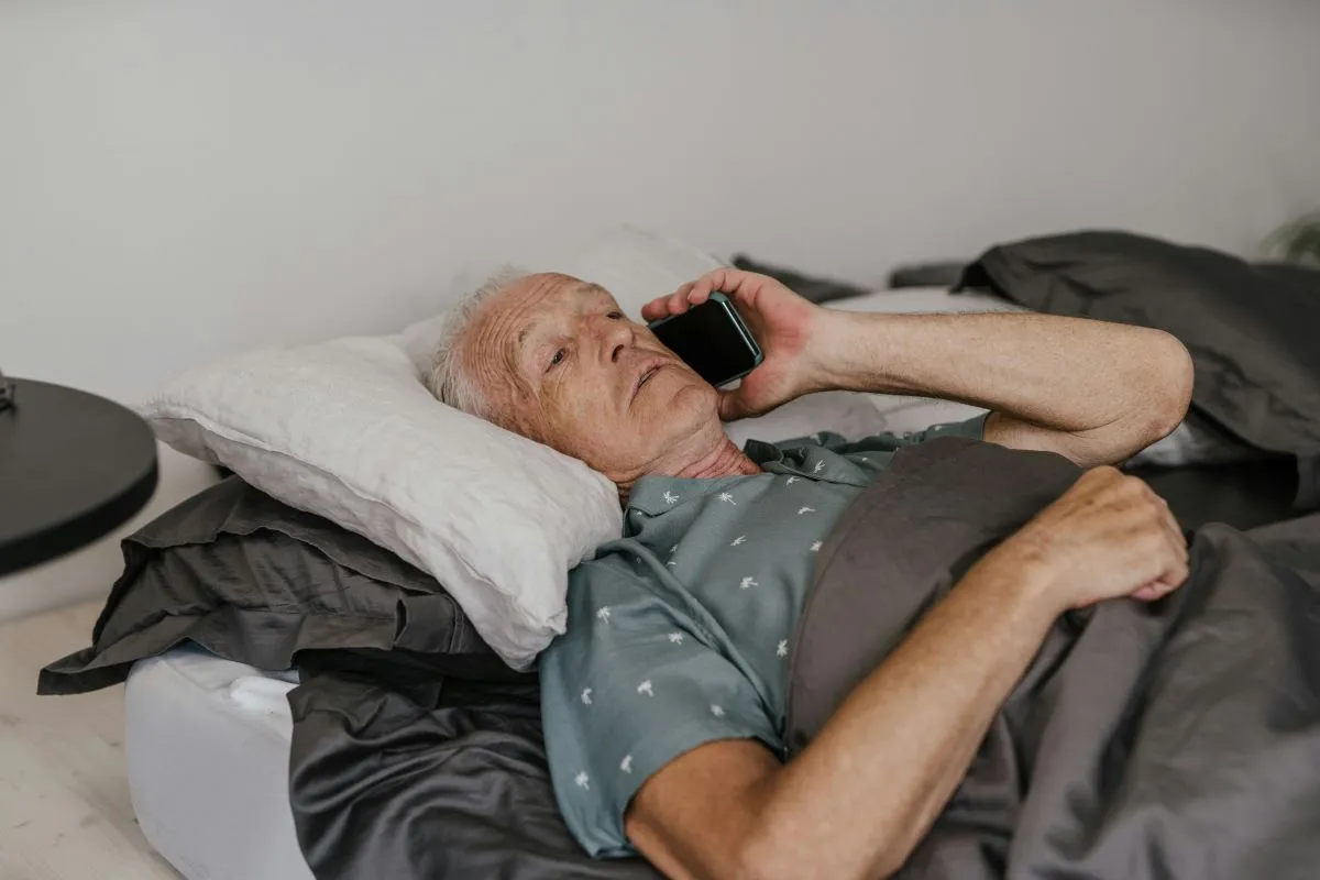 An older adult talking on a cell phone at home