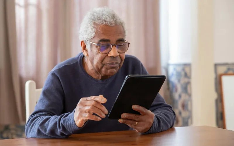 Senior using a free government tablet with internet at home for daily online activities