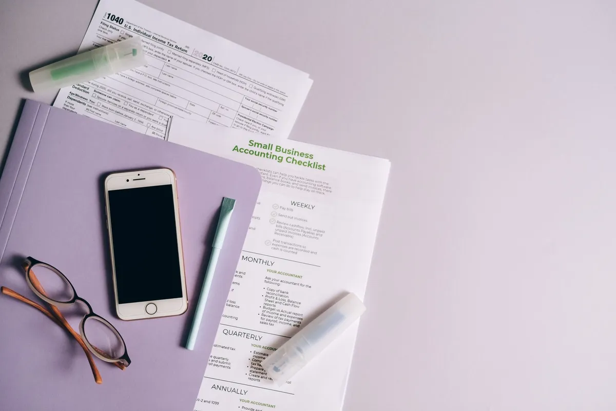 Manila folder with W-2 forms, a Social Security card and a blank check on a desk