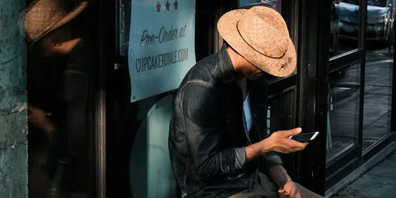 Introducing free government phone unlimited talk and text (Image By Unsplash) Nguồn: https://unsplash.com/fr/photos/homme-en-veste-en-cuir-noir-et-chapeau-fedora-marron-assis-sur-une-chaise-LlbciNqeGS4